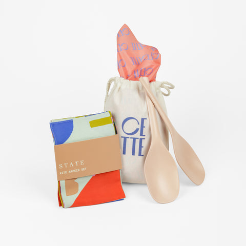 Colorful napkin set with two pink serving spoons and a CETTE canvas bag with tissue paper