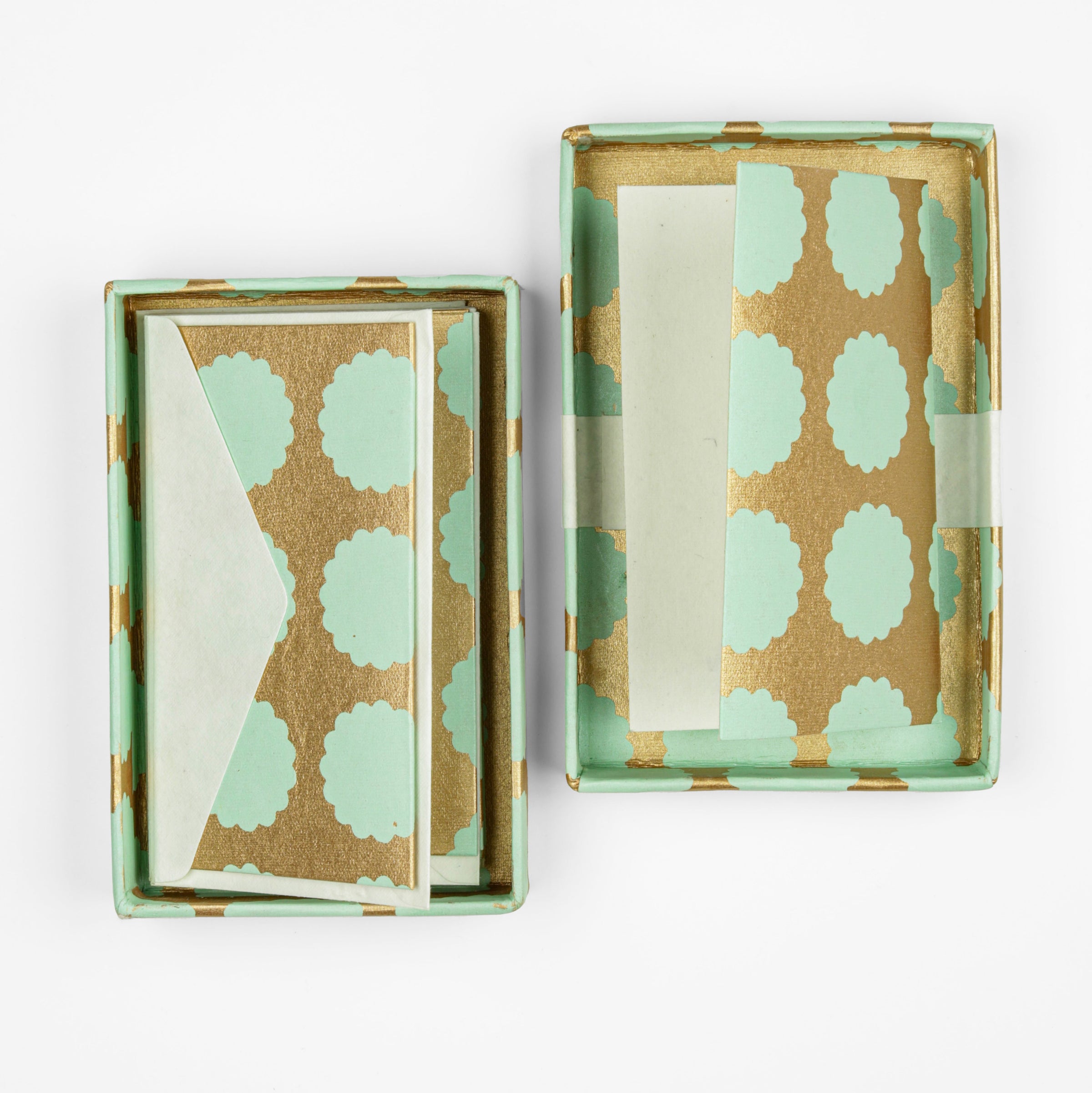 An open box of copper cards with mint green details 