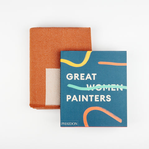 A Manifatura rust and peach colored wool blanket and Phaidon's Art book Great Women Painters