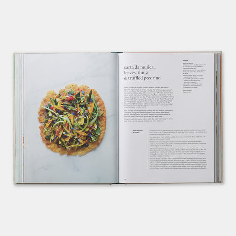 open view of cookbook On Vegetables showing a recipe and a colorful vegetarian dish