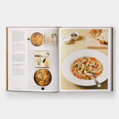 an open view of the cookbook showing photographs of food prep and a bowl of chicken noodle soup