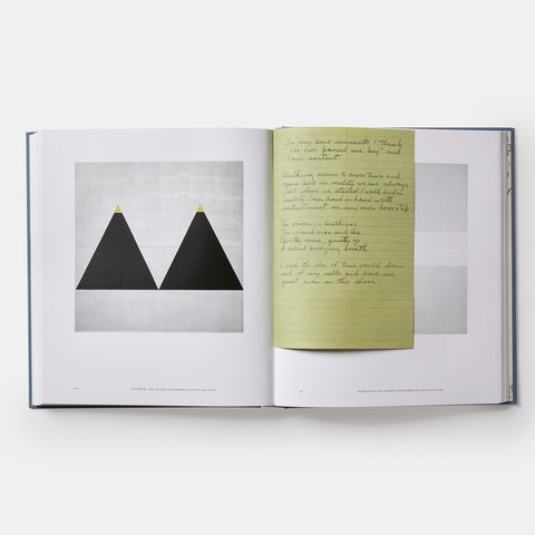 inside view of Agnes Martin book with special facsimile pages of her handwritten notes and showing a minimalist painting of two black triangles