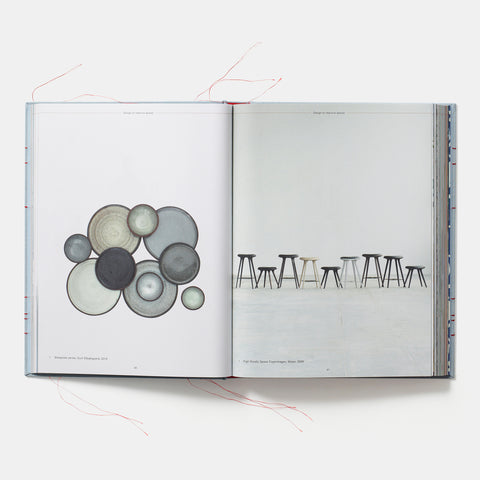 interior pages of The Red Thread: Nordic Design showing an arrangement of gray plates and some minimalist stools