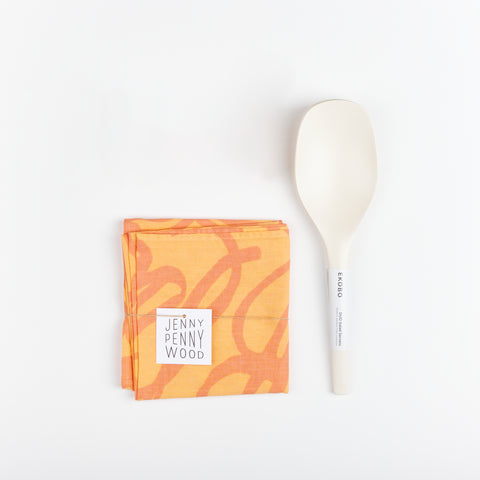 White Ekobo Bamboo minimalist Serving spoons and a melon and tangerine colored Jenny Pennywood cotton Linen home textile