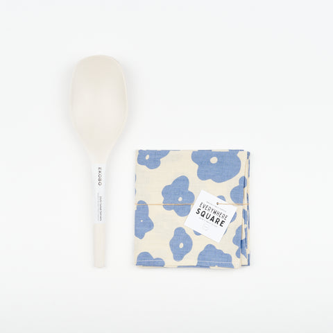 White Ekobo Bamboo minimalist Serving spoons and an off-white and slate blue colored Jenny Pennywood cotton Linen home textile