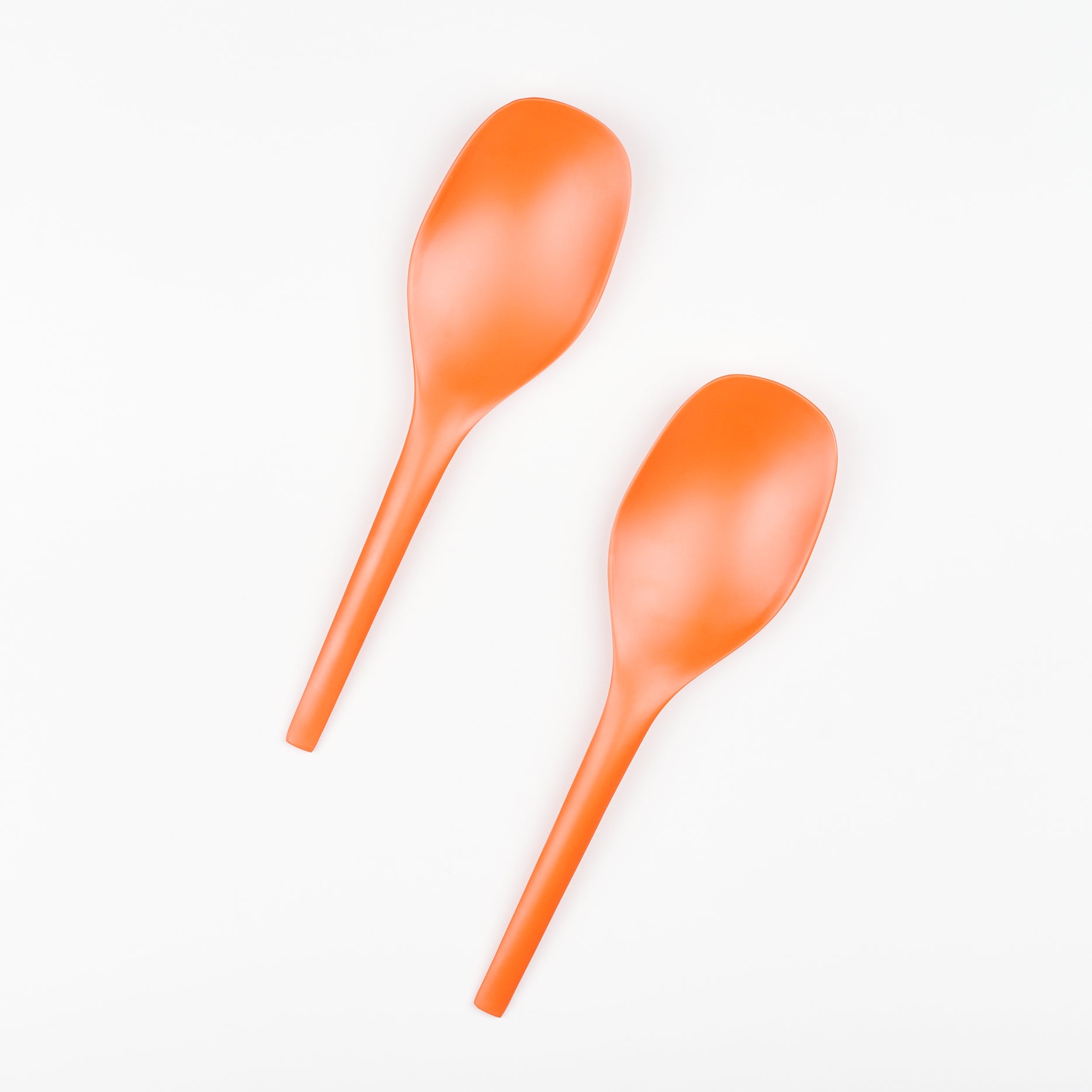 Two bright orange serving spoons side by side 