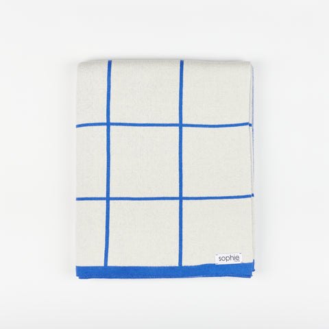 Sophie Home grid cotton knit throw blanket in cobalt folded into a rectangle shape