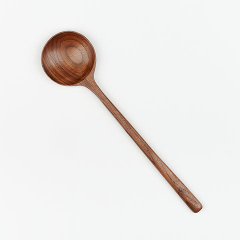 A wooden walnut cooking spoon with round head shape