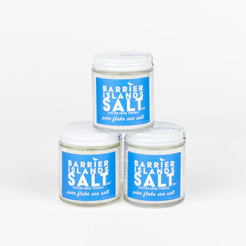 a stack of three jars of flake sea salt with bright blue labels