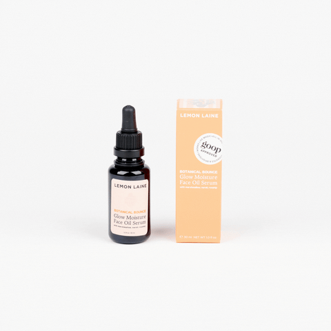 Dropper bottle of Lemon Laine Glow Moisture Face Oil Serum on a white background, with an apricot-color box rotating next to it.