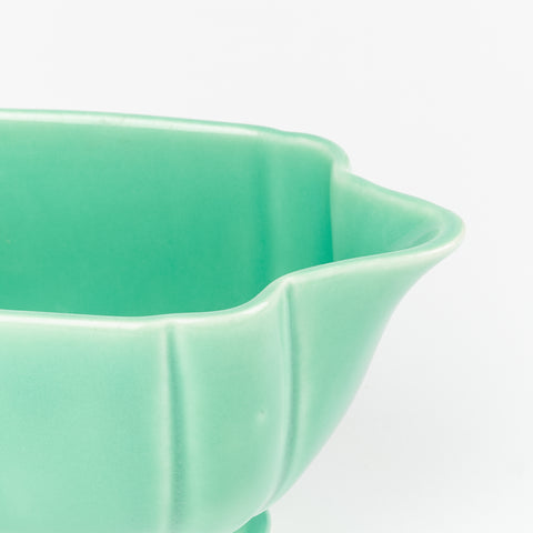 a close up of the spout of a mint green small creamer pitcher