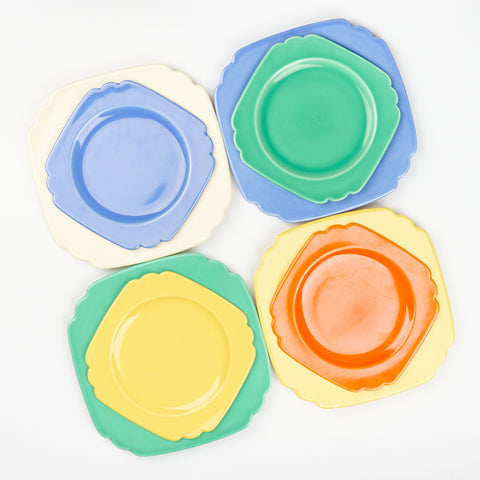 four dinner plates and four salad plates in mismatched colors