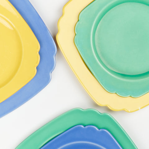 blue, yellow and green ceramic plates with smaller plates sitting on larger ones