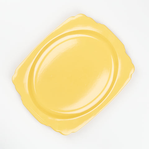 a squarish oval shaped vintage serving platter in a bright cheerful yellow