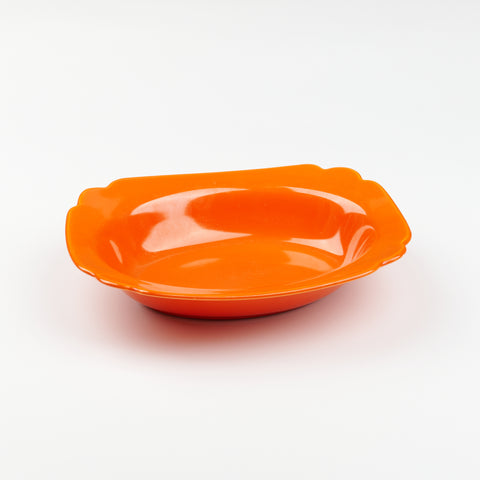 A serving bowl in bright red on a white backdrop