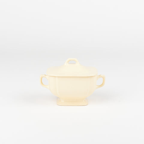 an off-white ceramic sugar dish with a lid and handles on each side