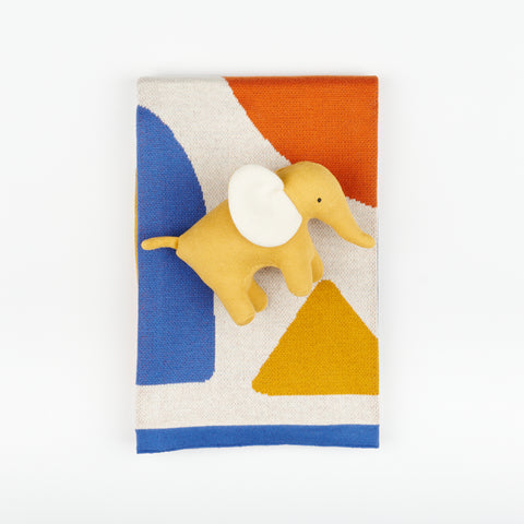 primary color folded baby blanket with plush yellow toy elephant on top of it