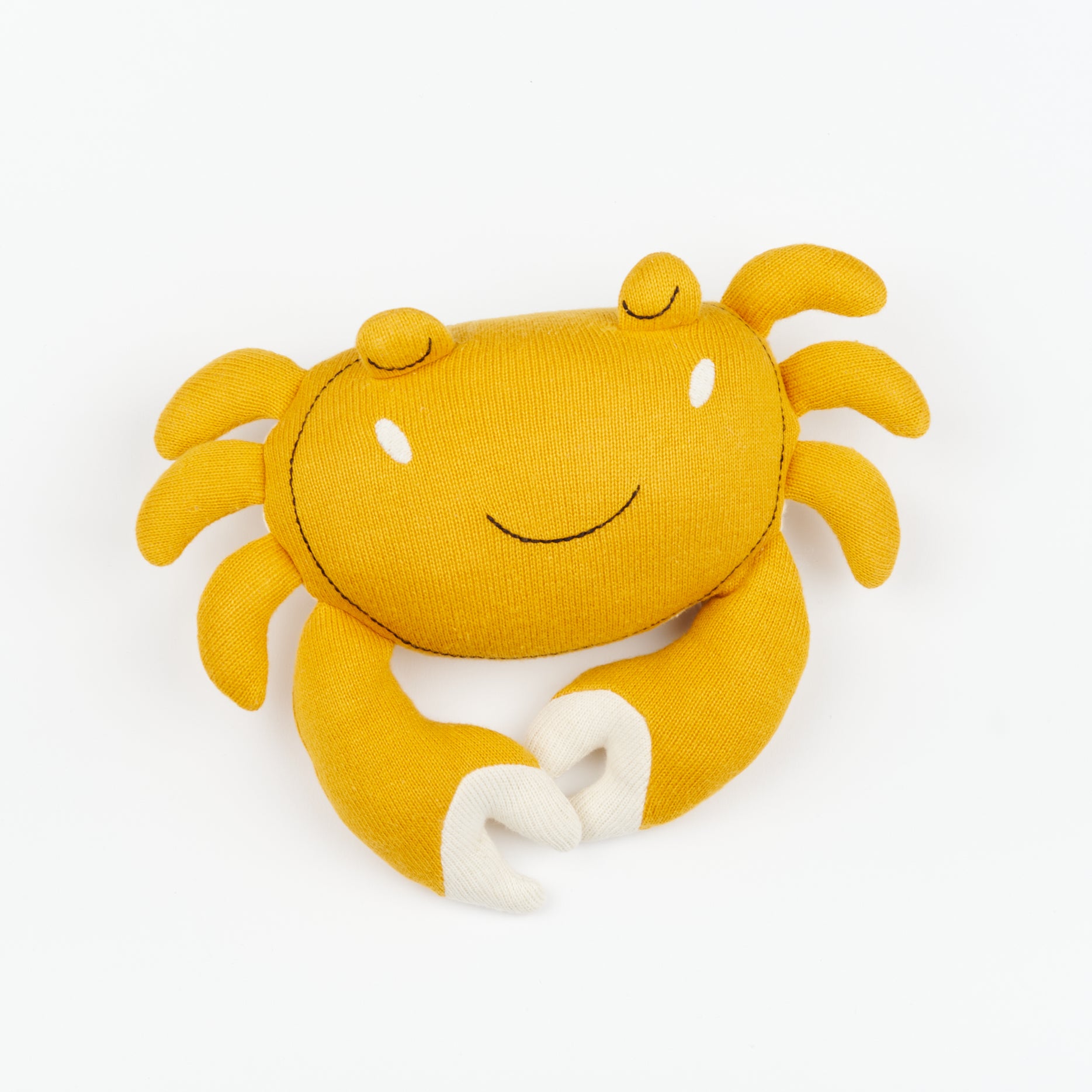 A plush soft toy yellow crab with white claws and smiling face