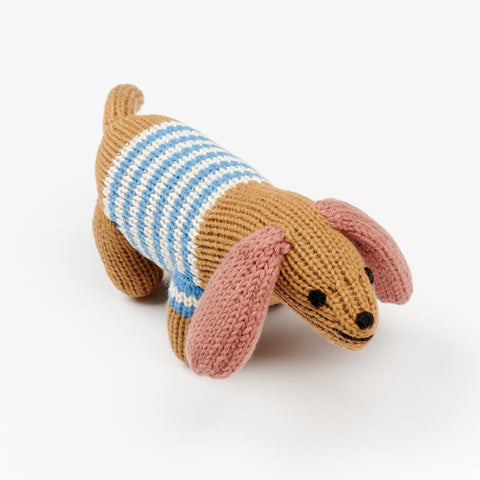 close up of the smiling face of a baby rattle in the shape of a small dog with long ears and a striped blue and white sweater