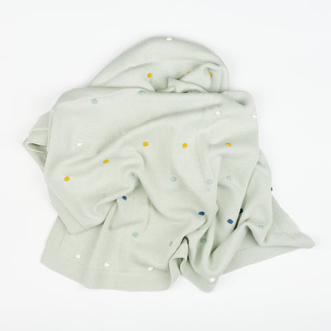 a pale green baby blanket bunched up in a pile