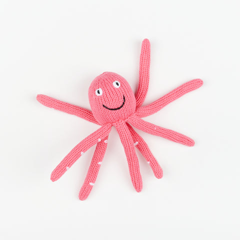 A plush knitted pink octopus baby rattle with a smiling face and outstretched arms