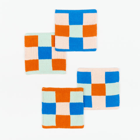 Four knit coasters by Verloop square square checkerboard pattern in jade and cobalt 