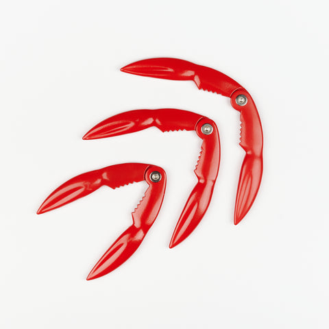 three red metal crab claw shaped lobster shell crackers open to varying degrees