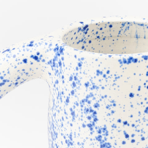 detail of handle and top opening of ceramic mug with blue and white speckle pattern