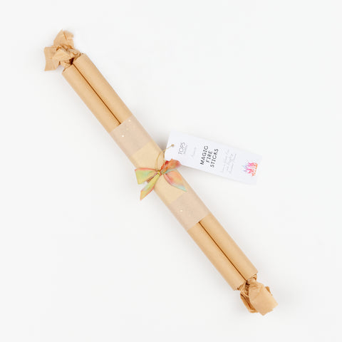 A single brown paper wrapped bundle of Tops Malibu Magic fire sticks with a small bow and a tag describing the product