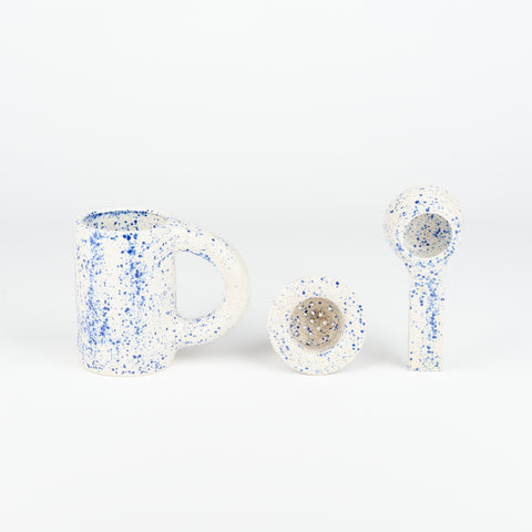 Three blue speckle ceramic pieces made by Utility Objects - A Nagai mug, tea strainer and a coffee scoop