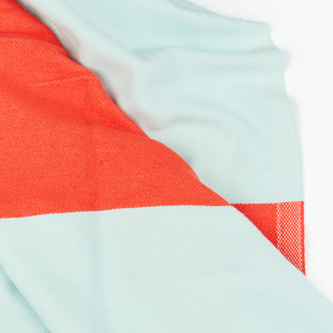 a close up of a red and light blue Turkish bath towel