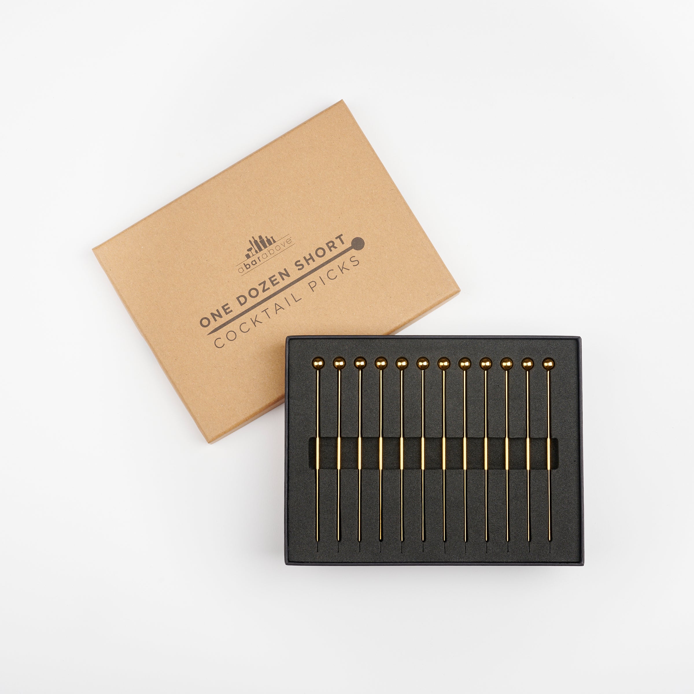 A Bar Above gold cocktail picks inside of their open box