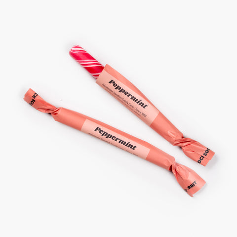 Large Swedish peppermint stick, partially unwrapped to show candy, part of the Peppermint Puzzling holiday gift set.