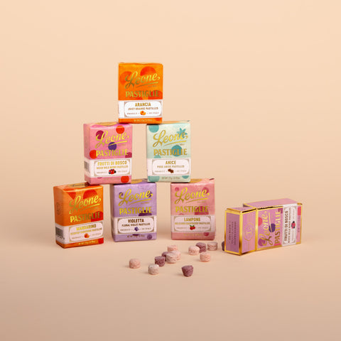 Pyramid of Leone candy boxes in assorted flavors with some candies spilling out of an open box.
