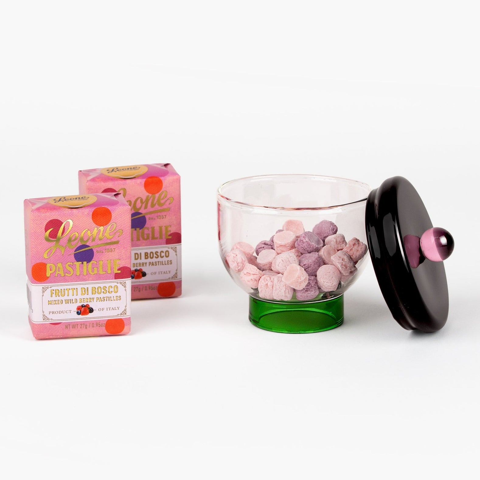 Front view of Eye Candy gift set showing Sophie Lou Jacobsen glass bowl half-filled with Leone candies and two wrapped candy boxes on a white background.