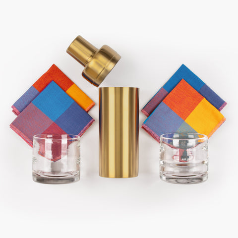 The Main Event gift set with handblown glass tumblers, brass cocktail shaker, and checkered cocktail napkins in Berry Patch colorway on a white background.