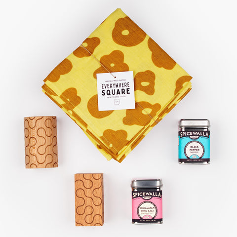 Shake It Up gift set with Jenny Pennywood Everywhere Square textile in yellow, Dusen Dusen wooden salt and pepper shakers, and Spicewalla spices.