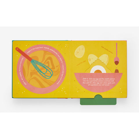 an open view of an interactive kids book on making cookies showing moving pull out pages and a whisk