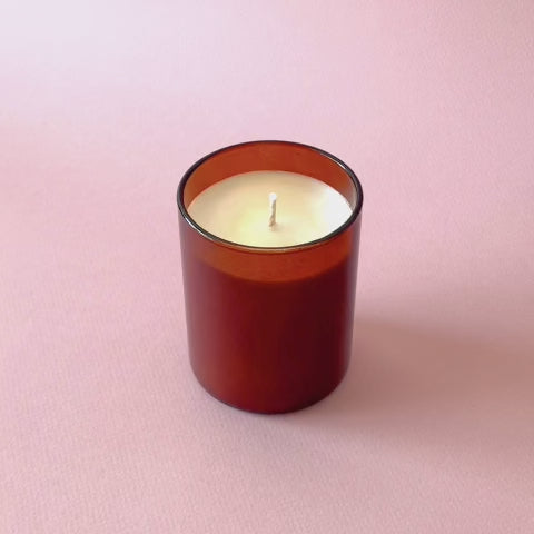 a video showing the lighting of a candle with a Botanica flameless lighter