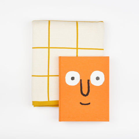 A Book and Blanket Gift set including Phaidon design book Jean Jullien and a Sophie Home Cotton Knit Throw blanket with a citrus yellow grid